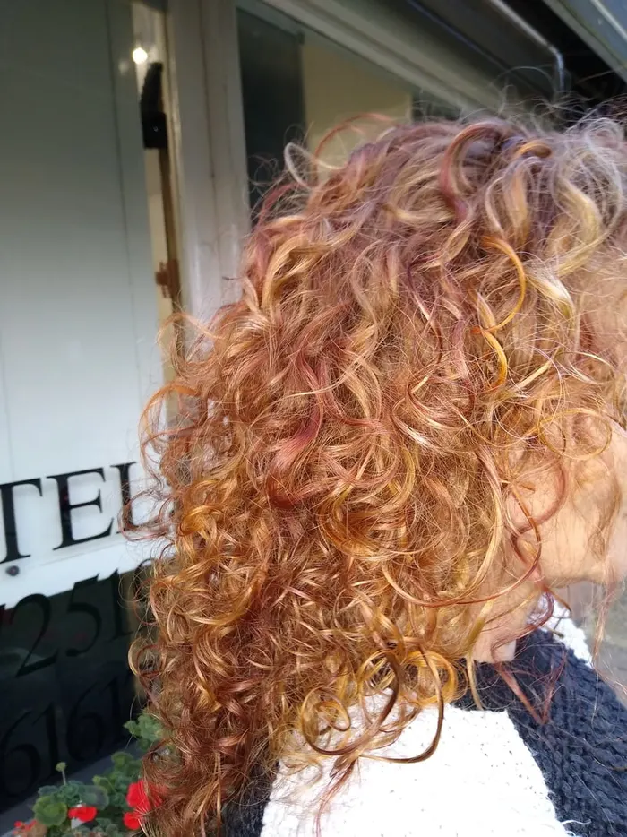 Copper and blonde spiral perm curls by Harvey's Hairdressers, Luton